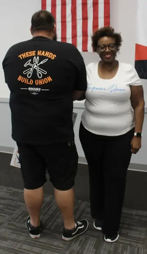 K. Patrice Williams standing with a SMART Local 104 sheet metal worker wearing a These Hands Build Union shirt